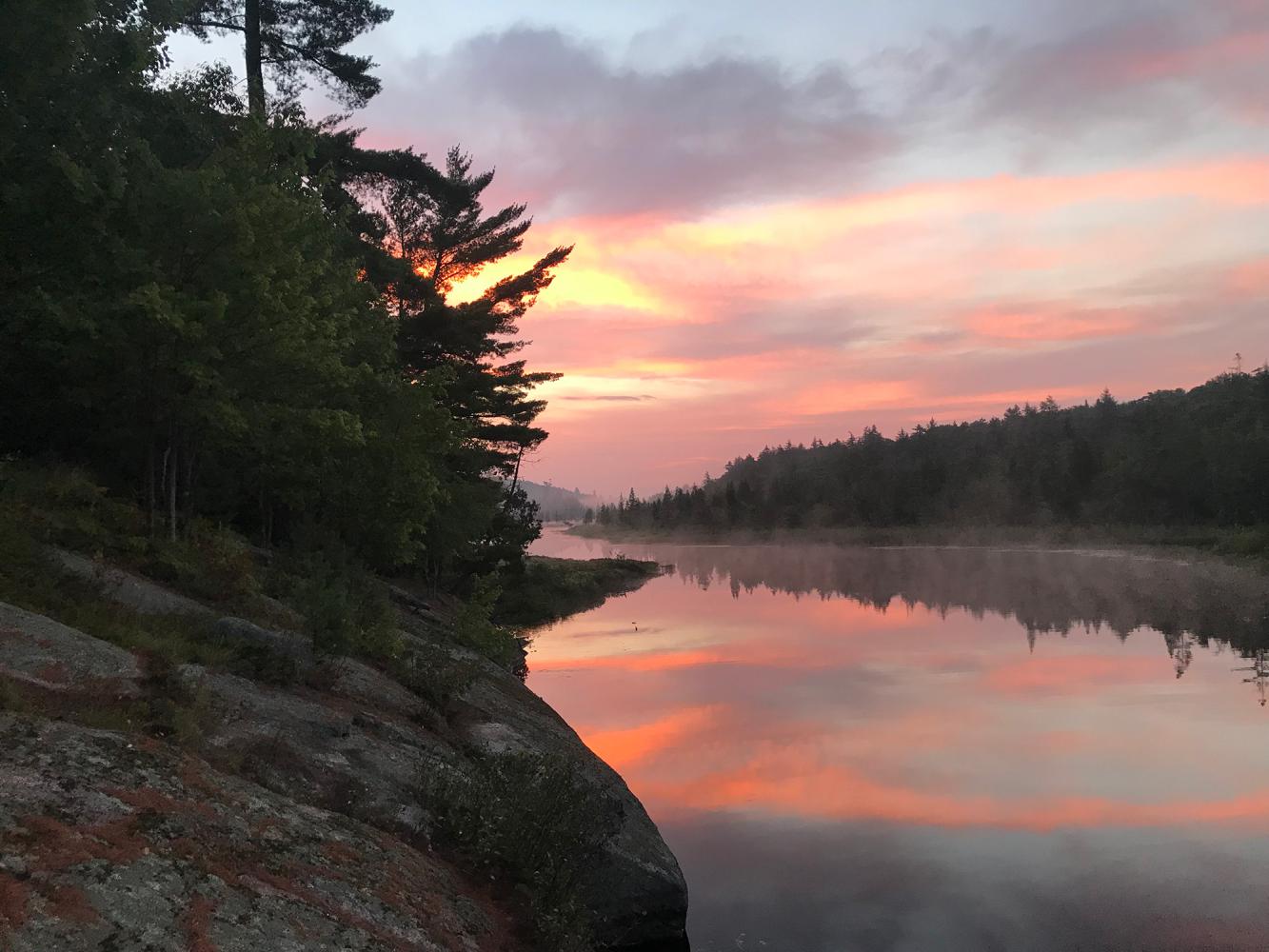 Sunrise over a river in the Adirondack mountains